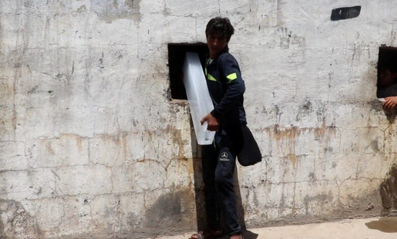 رجل يحمل قالب ثلج في دير الزور